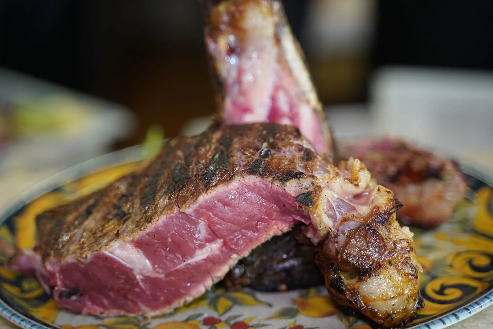 Una bistecca alla fiorentina tagliata al sangue, servita su un piatto decorato