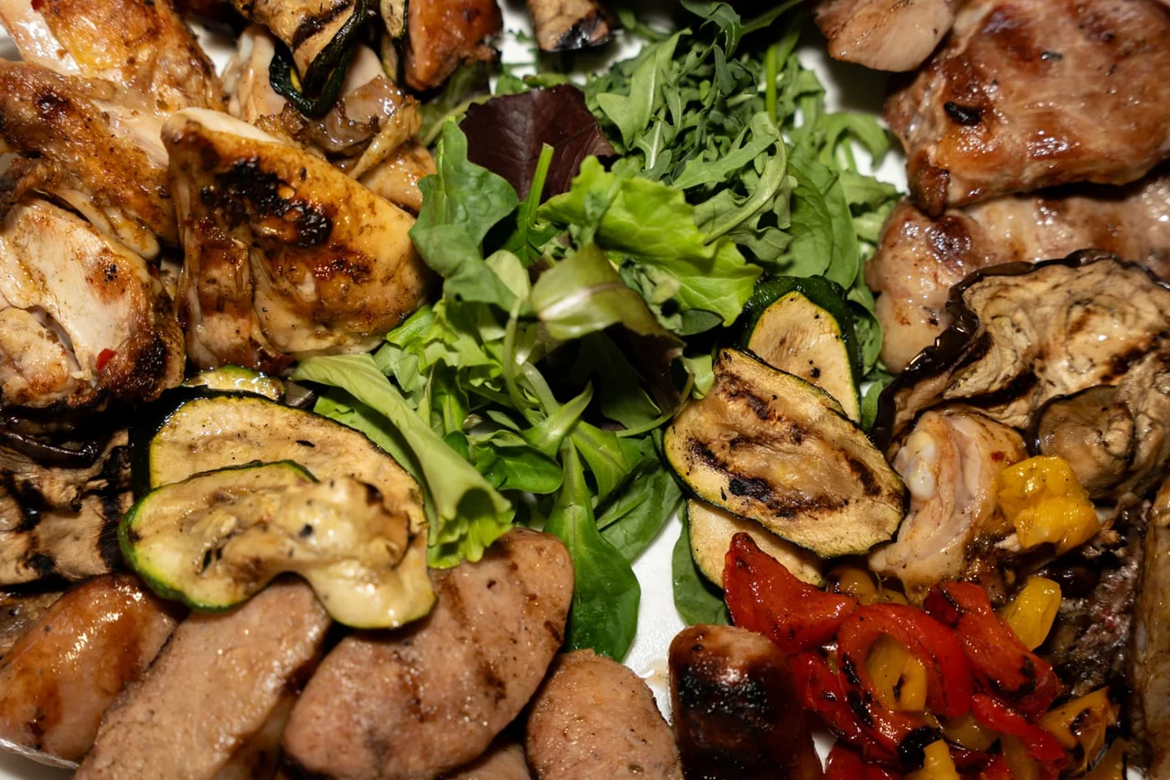 Grilled meat with grilled vegetables and salad, seen close up