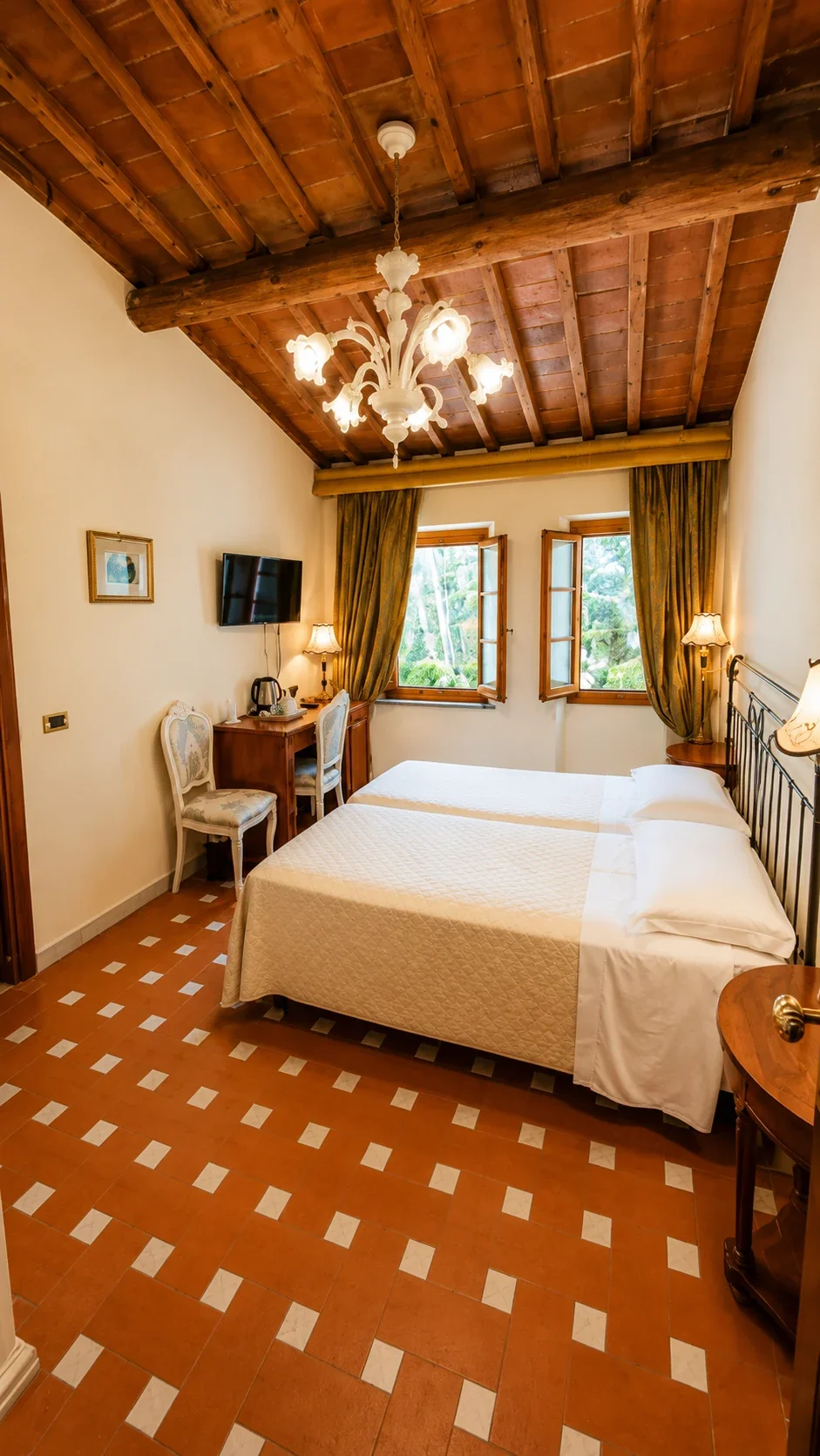 La Camera Classic Twin 406 con letto matrimoniale, soffitto in travi e cotto e due finestre affacciate sugli alberi
