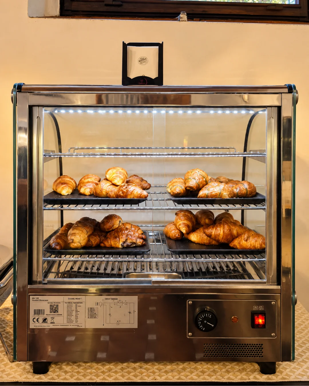 La vetrina calda con i croissant appena sfornati, semplici e farciti, nella sala della colazione