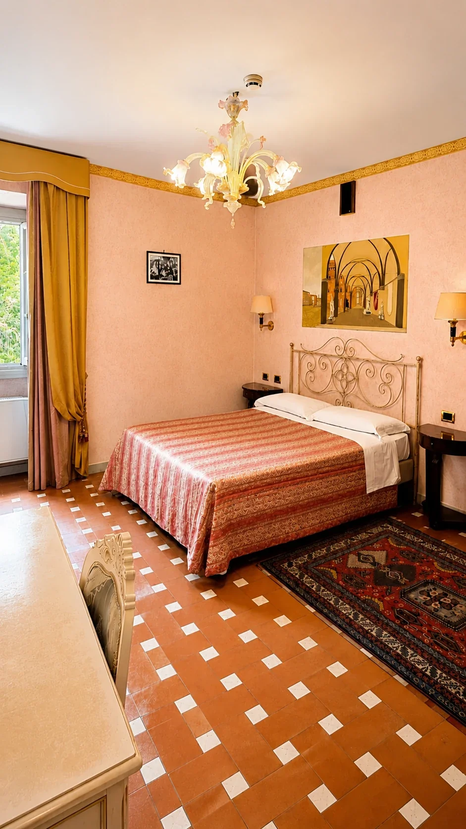 La Camera 206 della famiglia Malegonnelle Il letto matrimoniale della Camera 206 tra le pareti rosate, il tappeto persiano e la grande finestra