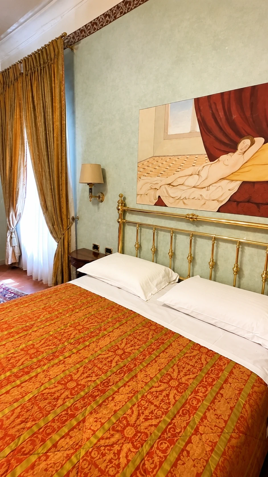 Il letto in ottone brunito sotto il dipinto murale della Camera Michelozzi