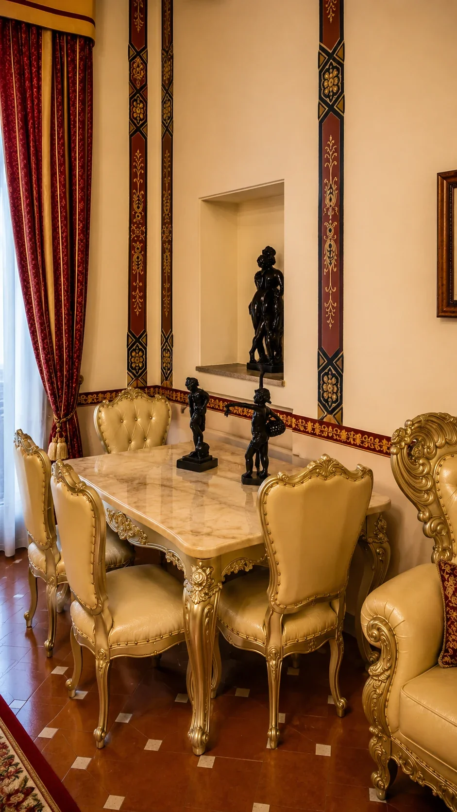 Il tavolo da pranzo con sedie chiare e statue decorative nella Junior Suite 109