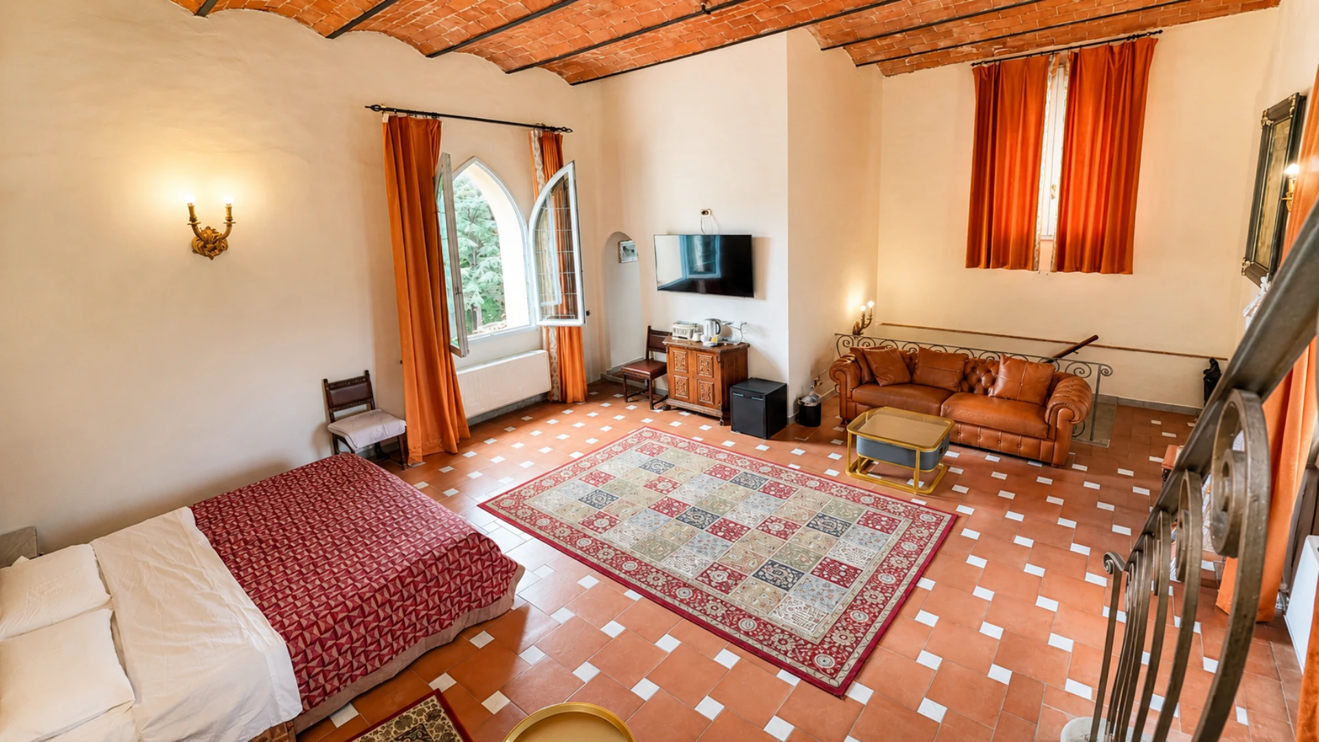 The King deluxe with its Chesterfield sofa, the television and the pointed arch window open onto the park