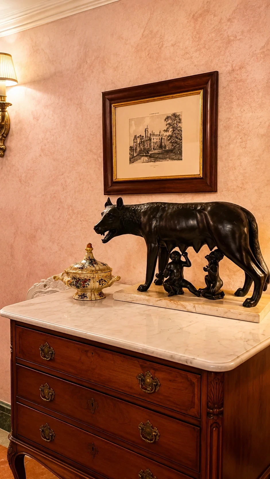 La scultura della lupa con i gemelli sopra il cassettone in legno della Camera 216