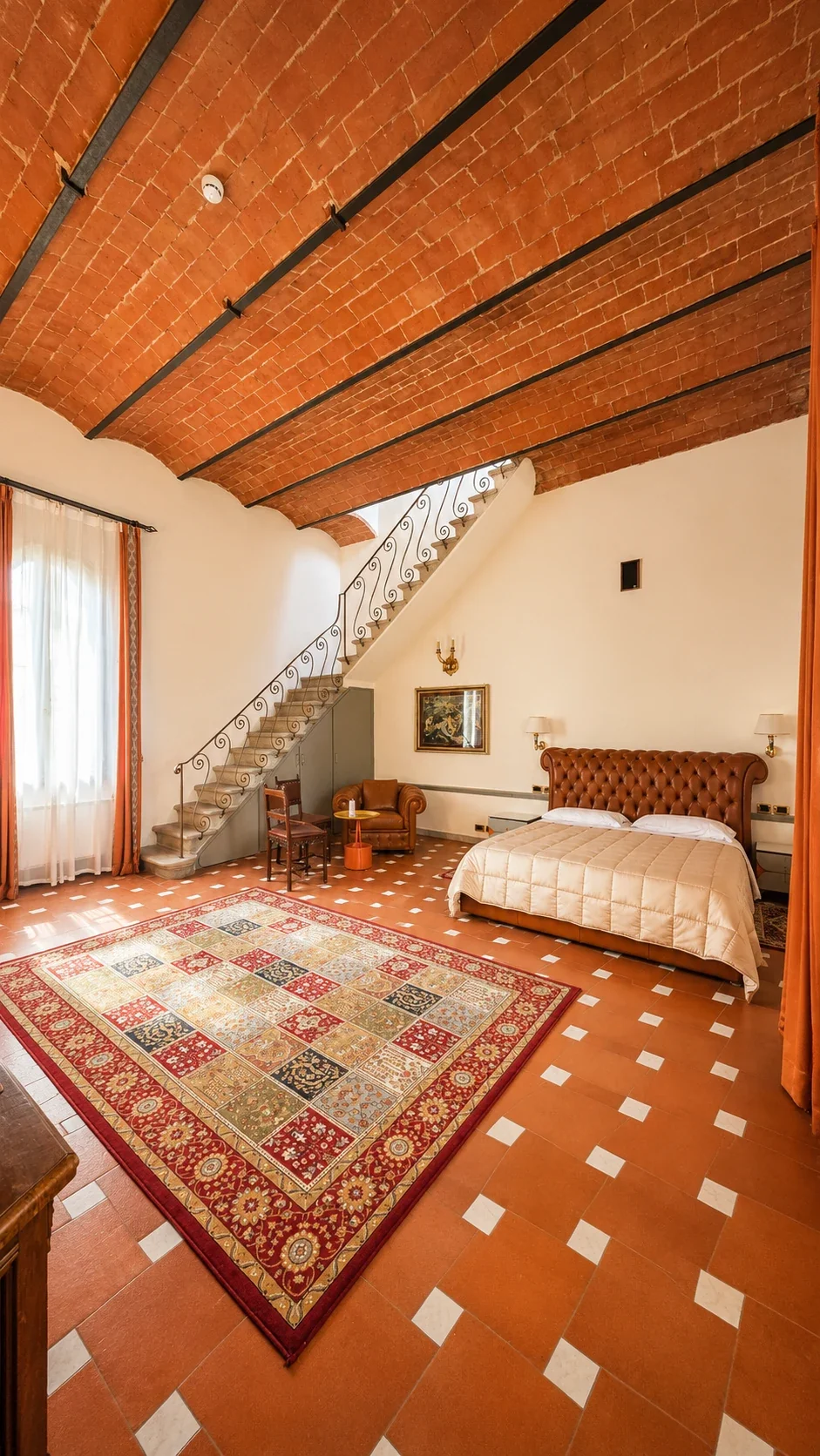 La King Deluxe 218 con letto capitonné, scala in pietra, volta in mattoni e grande tappeto geometrico