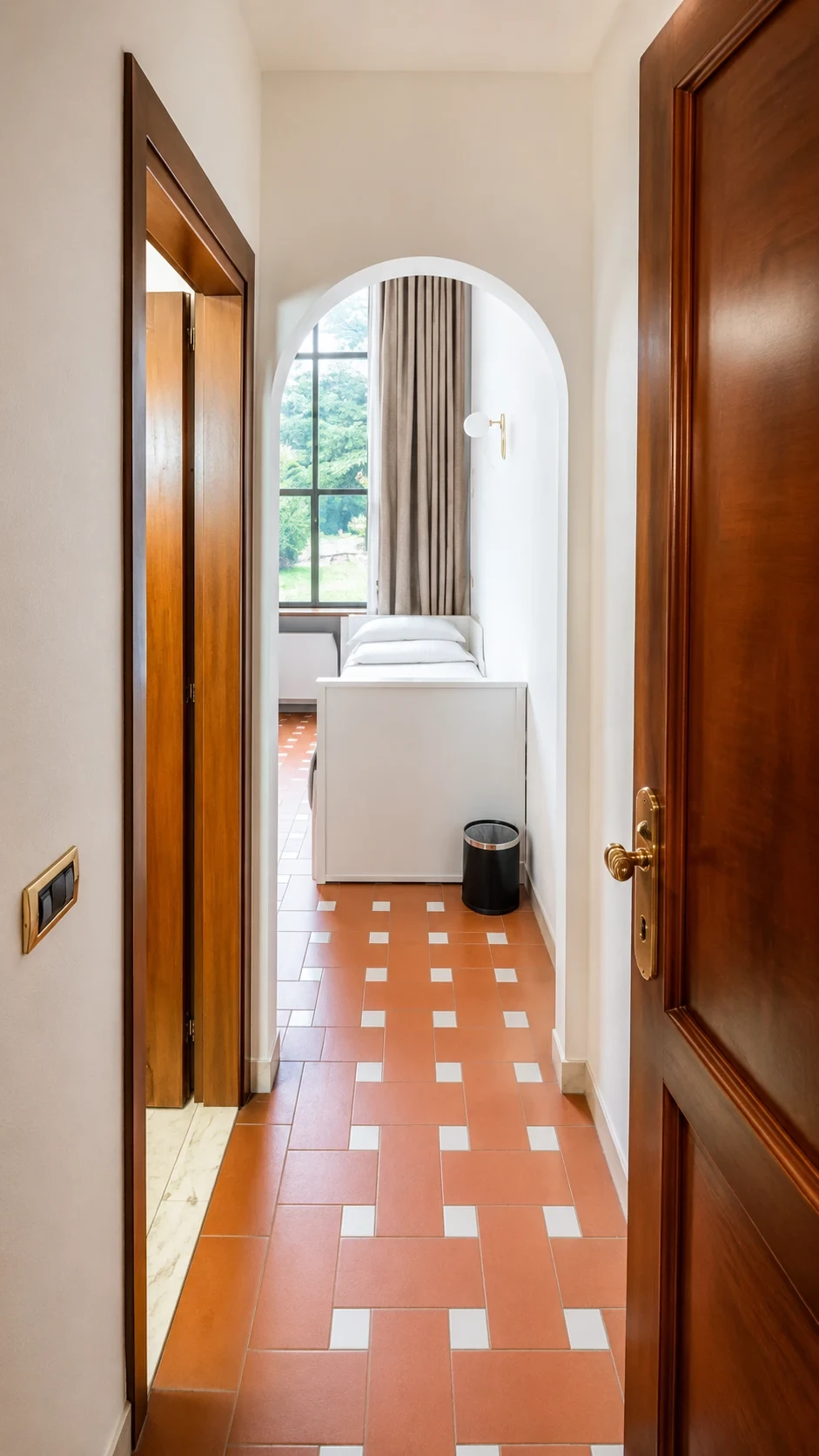 Il salottino chiaro del Loft 301 visto dall'ingresso, con la luce naturale del giardino