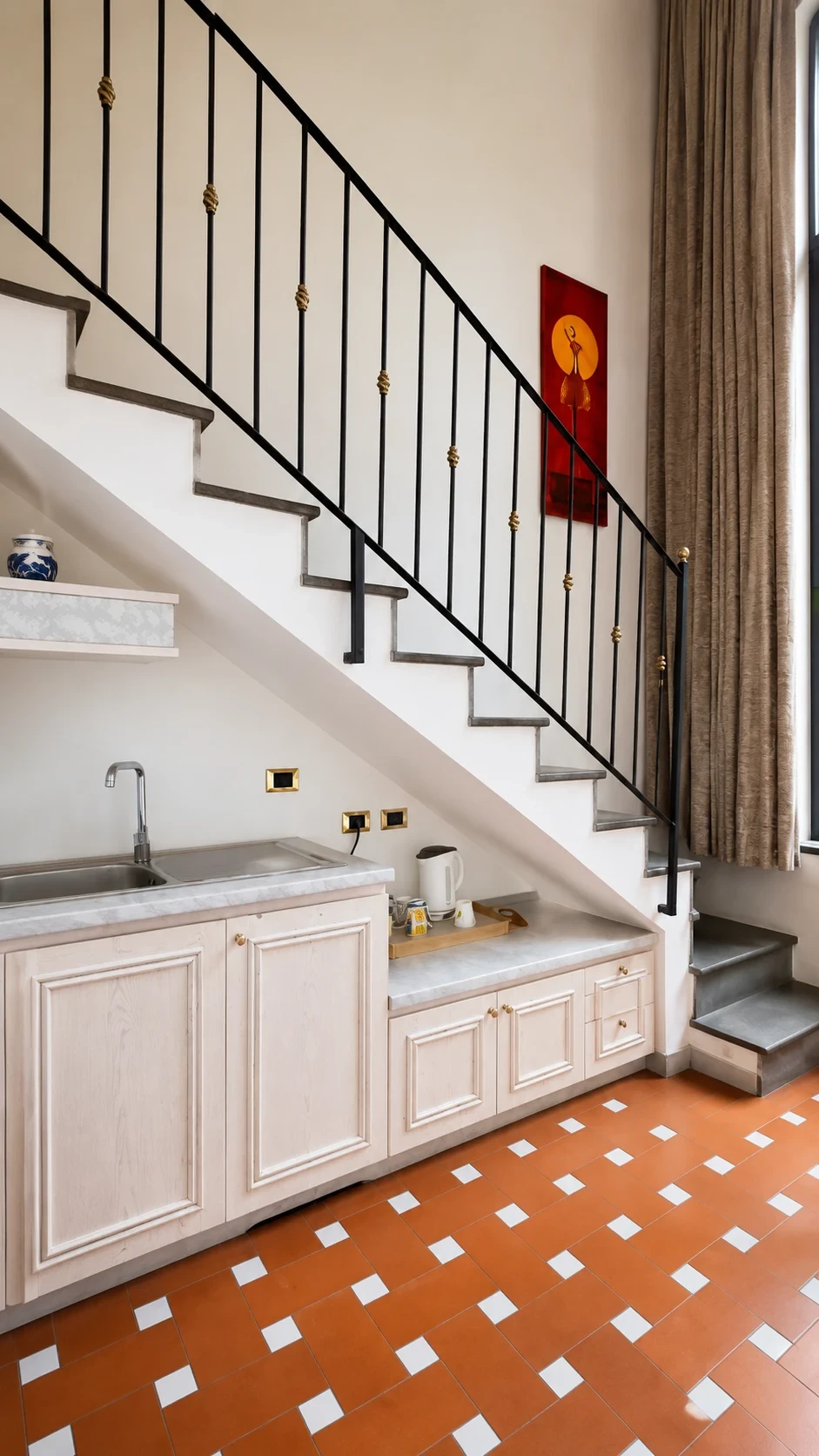 La cucina sotto la scala del Loft 301 con piano cottura, lavello e tisaniera