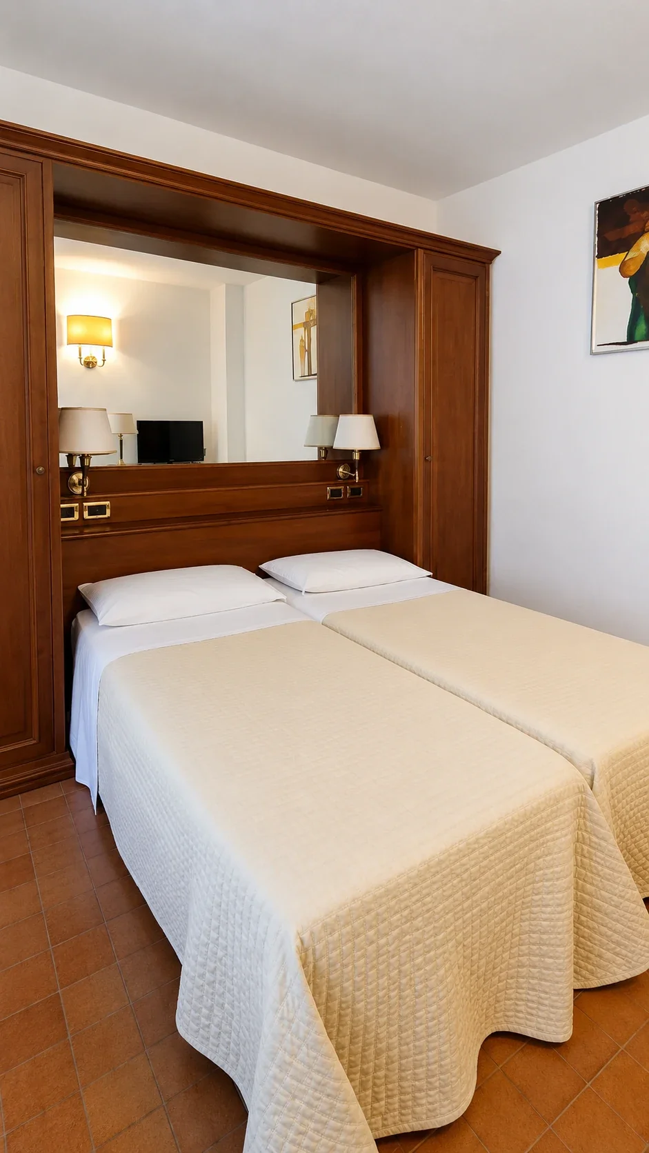 I due letti del piano superiore del Loft 302 sotto la testata in legno con lampade da lettura