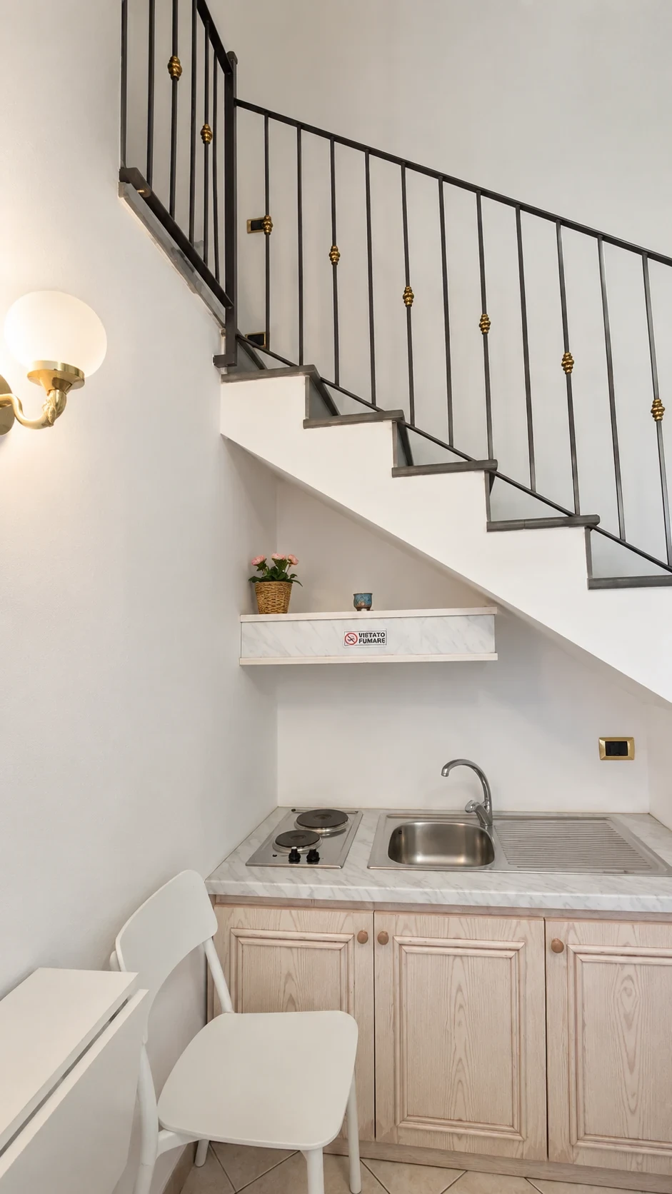 La scala del Loft 304 con ringhiera in ferro e piccola mensola bianca decorata