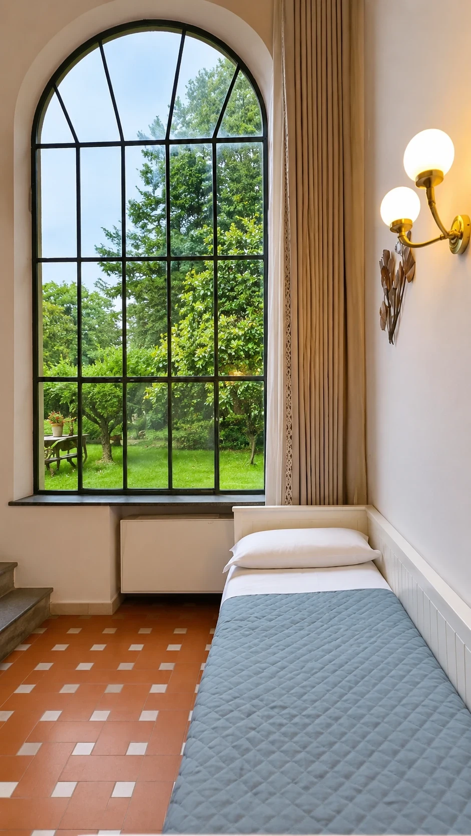 Il letto singolo del Loft 304 sotto la finestra panoramica aperta sul parco