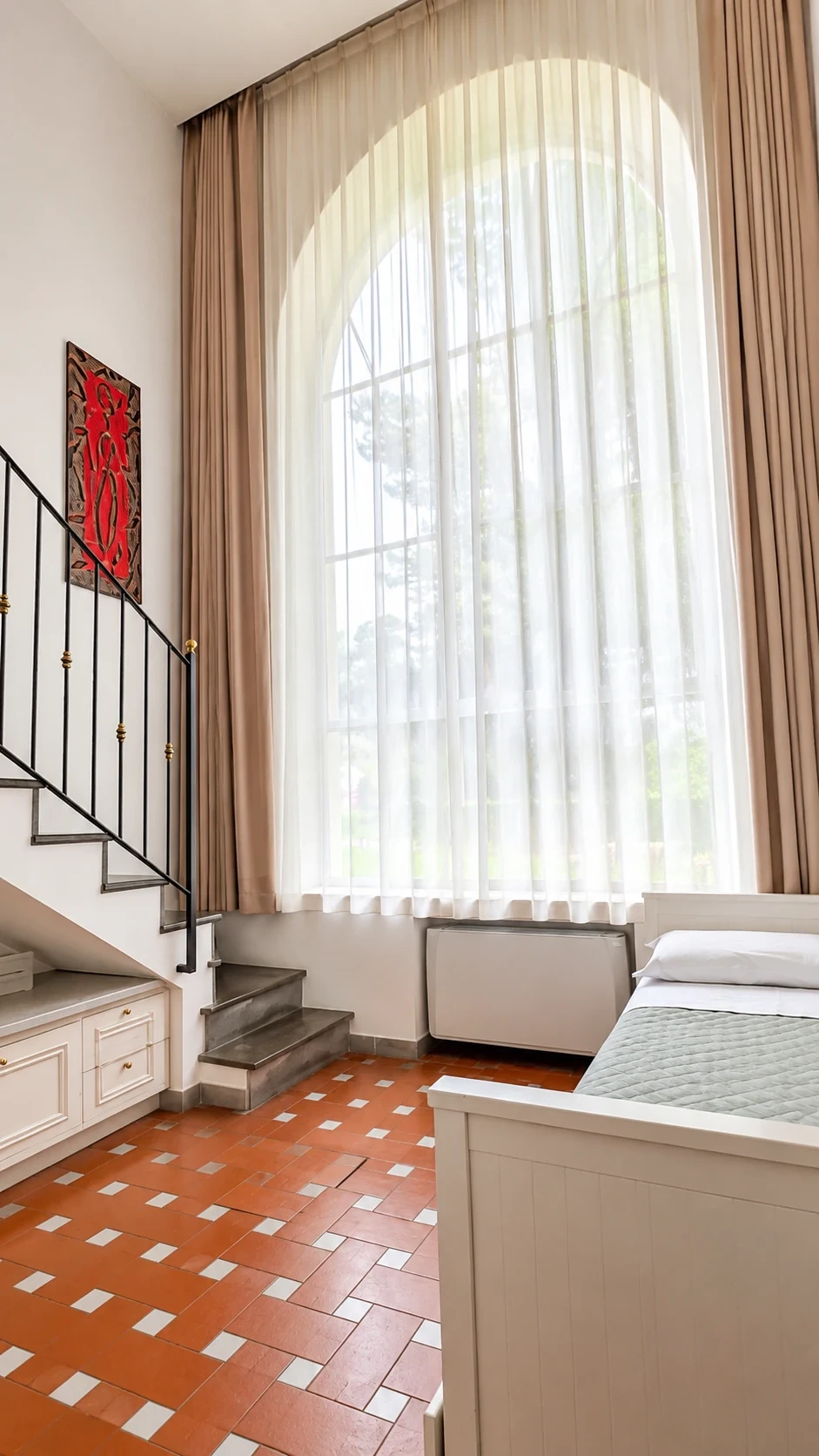 La grande finestra del Loft Voltumna illumina la scala e il letto al piano inferiore