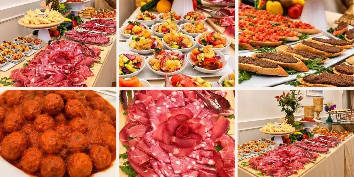 The Tuscan buffet: cured meats laid out like a rose, panzanella in small bowls, crostini, meatballs in tomato sauce and the table with the pecorino cheeses
