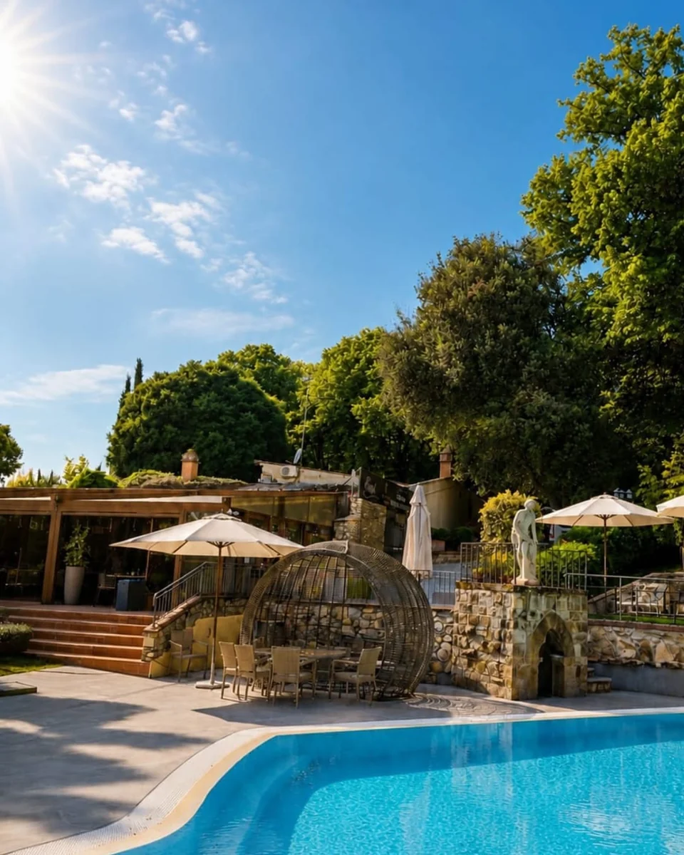 The poolside with the bar pergola, shaded tables and the round wicker chair
