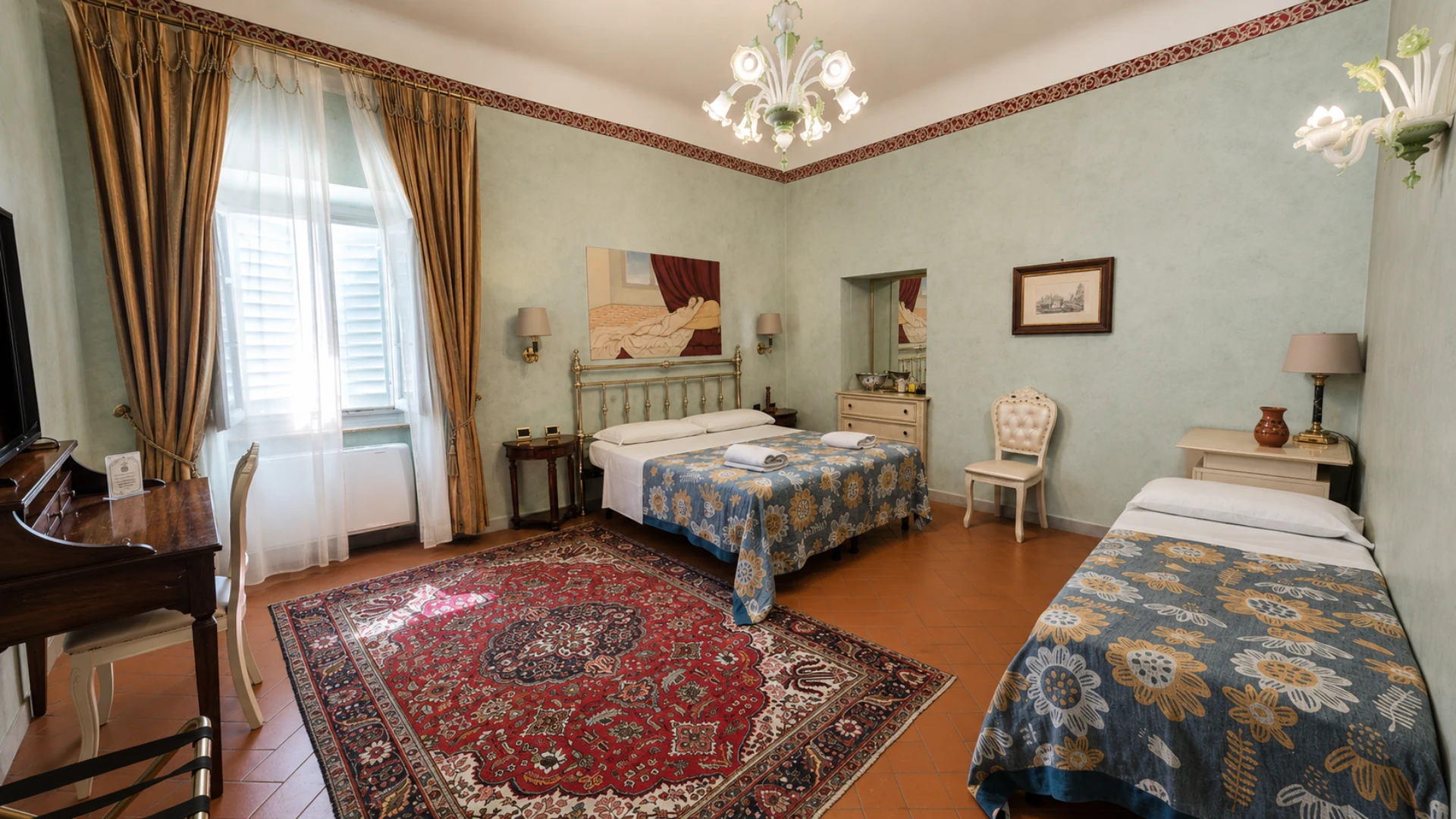 A Premium room with sage green walls, a brass bed, a blown glass chandelier and a second bed