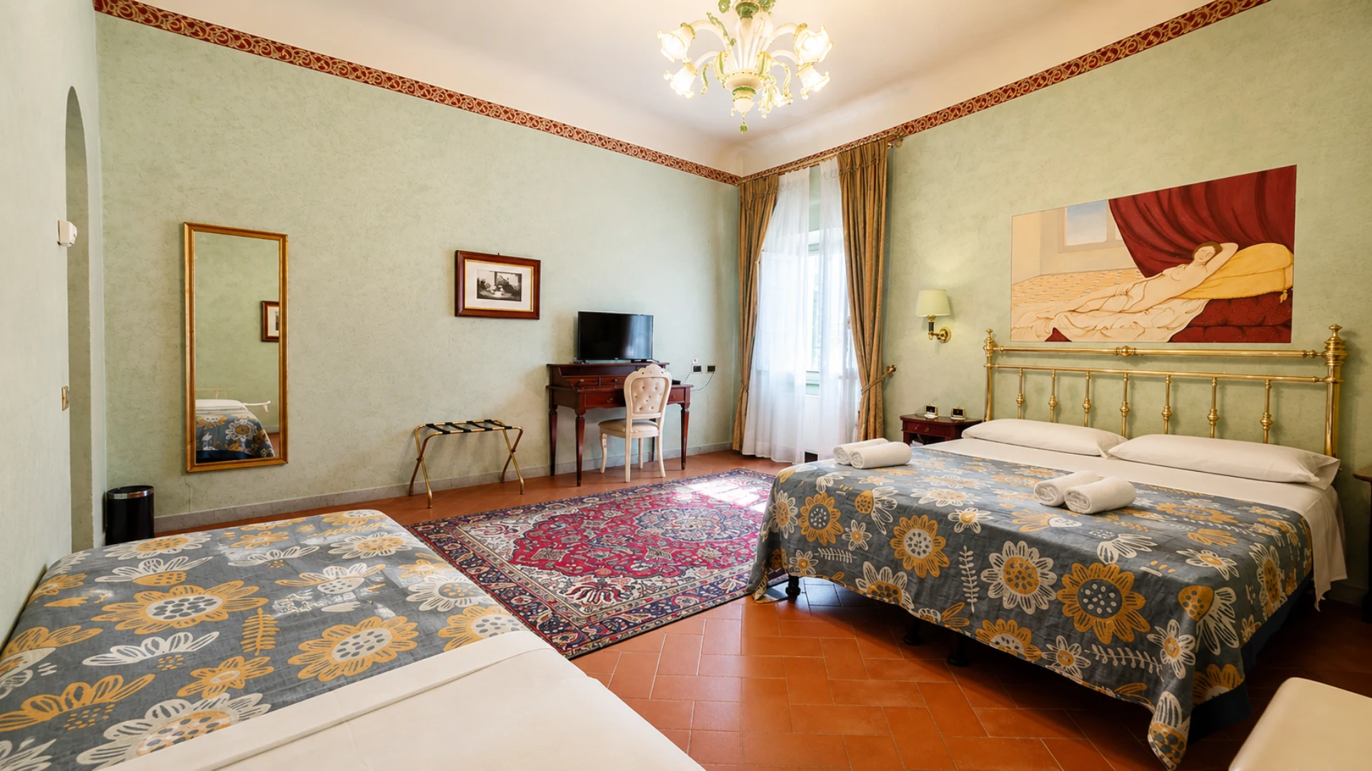 A Premium room with two beds, a walnut desk and the painting of a reclining woman above the brass headboard