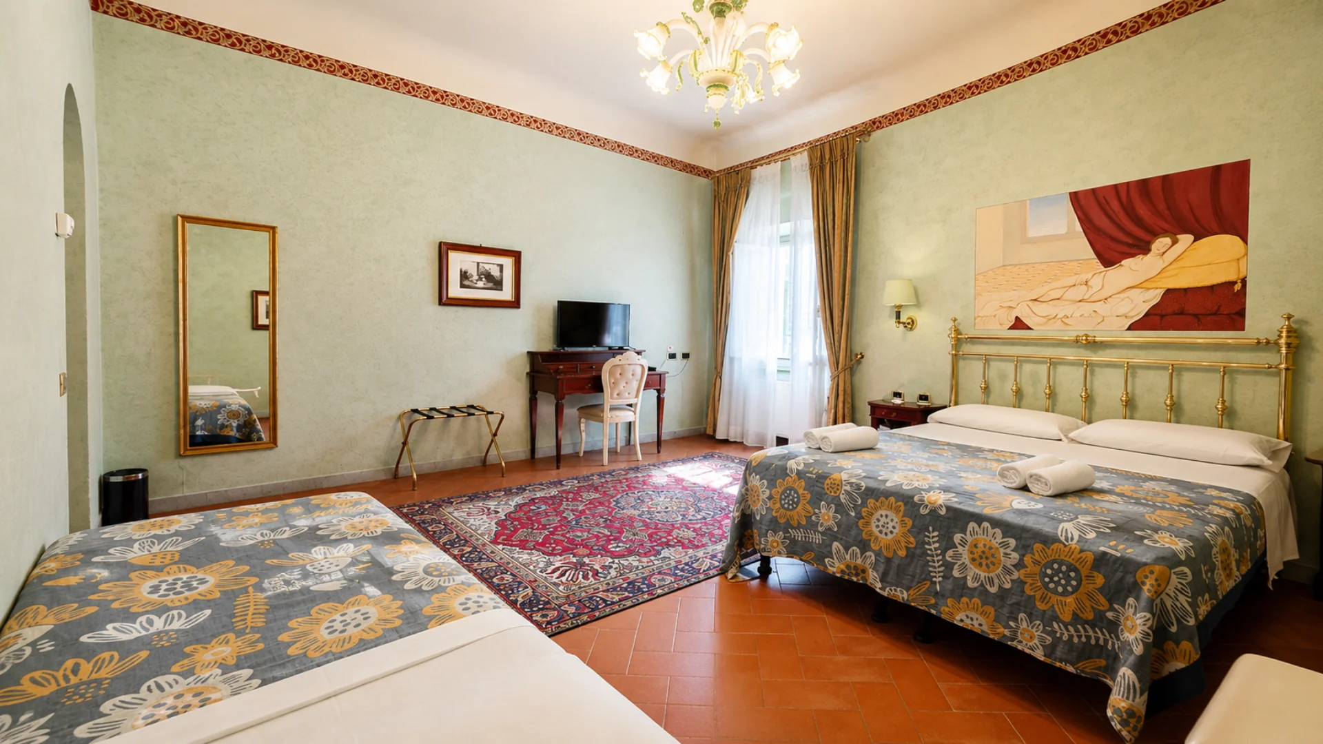 A Premium room with two beds, a walnut desk and the painting of a reclining woman above the brass headboard