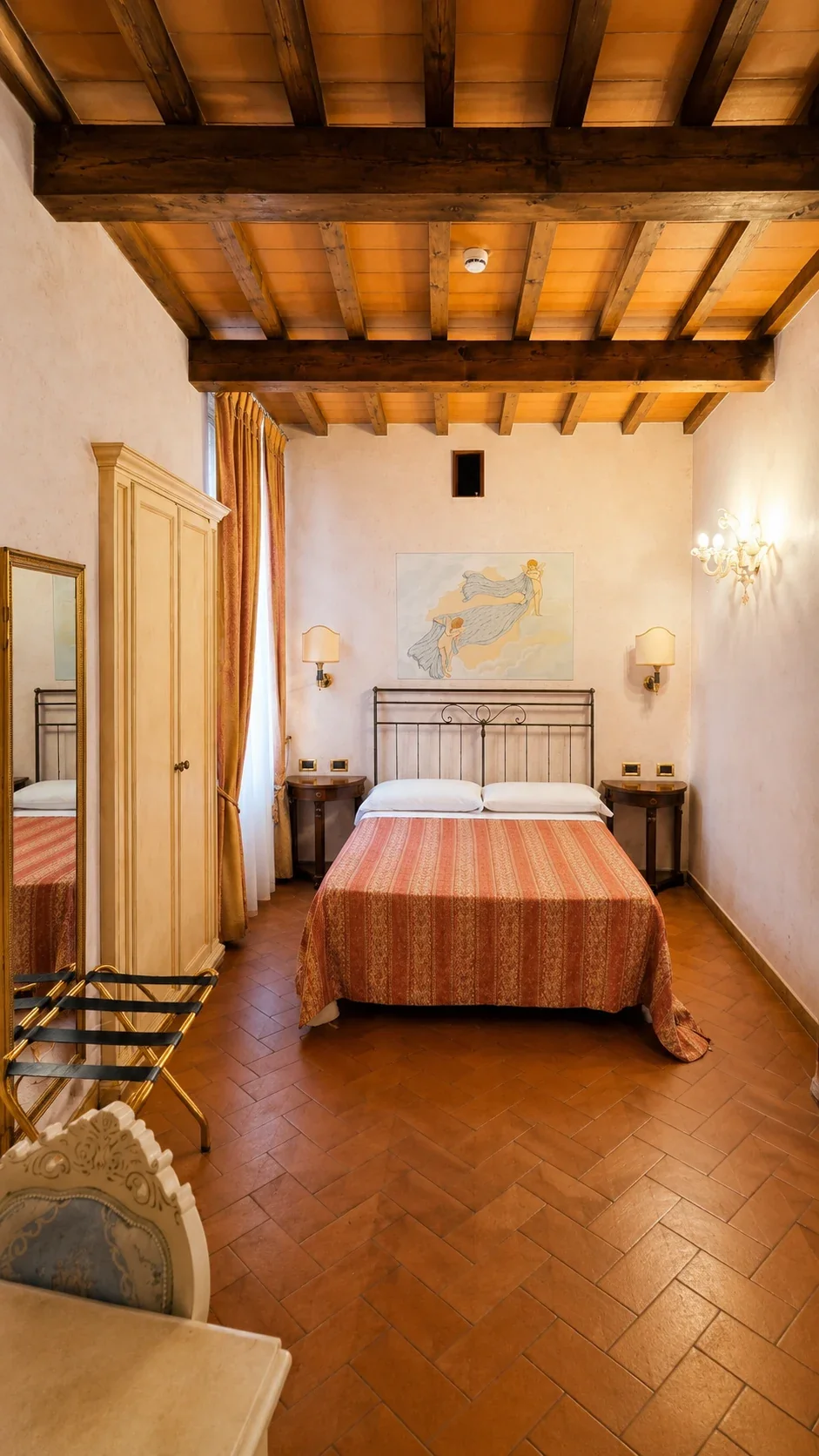 Il letto della Stanza di Zefiro Il letto della Camera 106 sotto le travi in legno e il dipinto dedicato a Zefiro