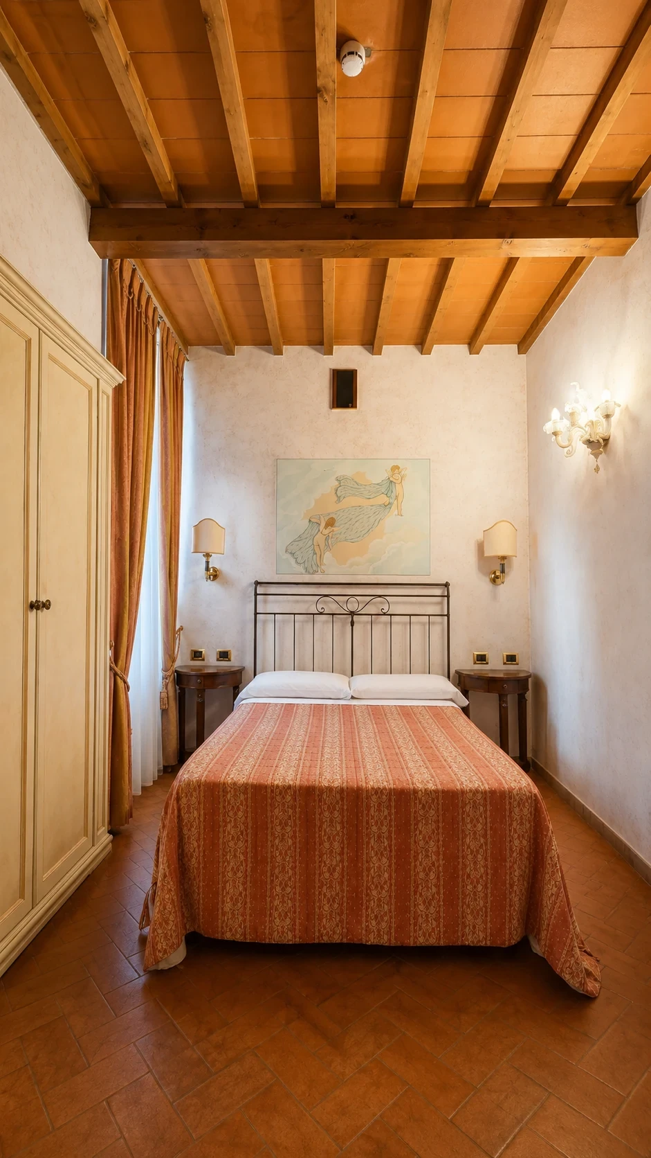 La Stanza di Zefiro con letto in ferro battuto, armadio chiaro e soffitto a travi