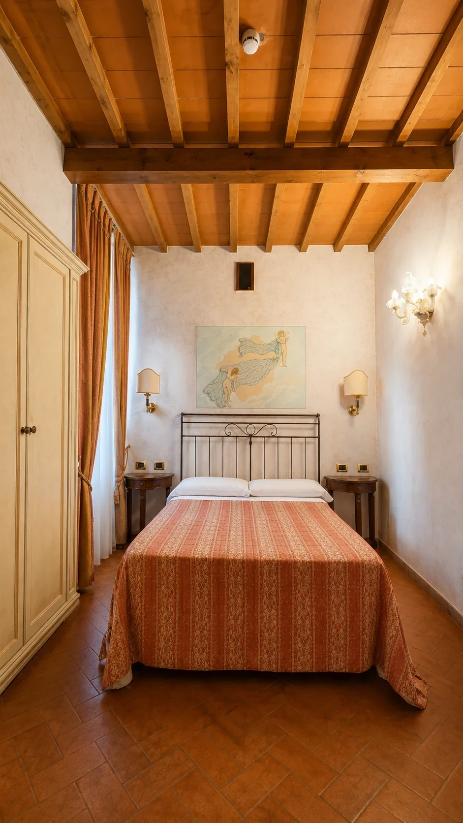 La Stanza di Zefiro con letto in ferro battuto, armadio chiaro e soffitto a travi
