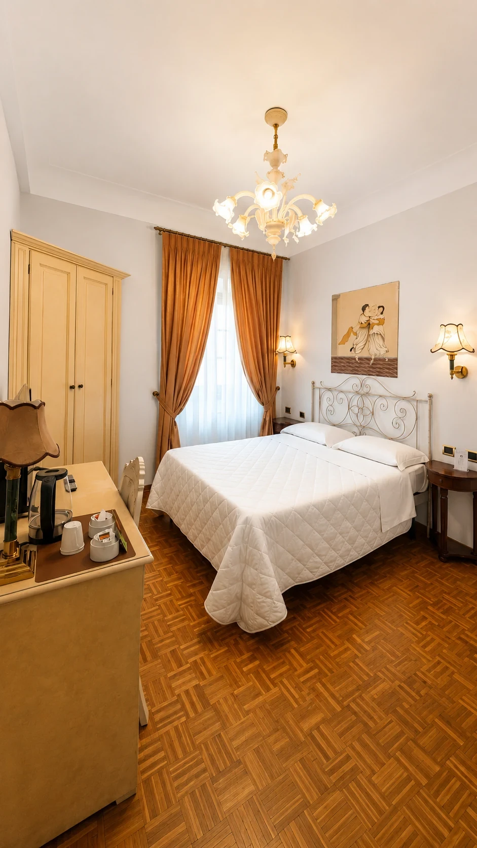 La Camera Premium 203 con letto in ferro battuto, dipinto di Harmonia, lampadario in vetro e tende dorate