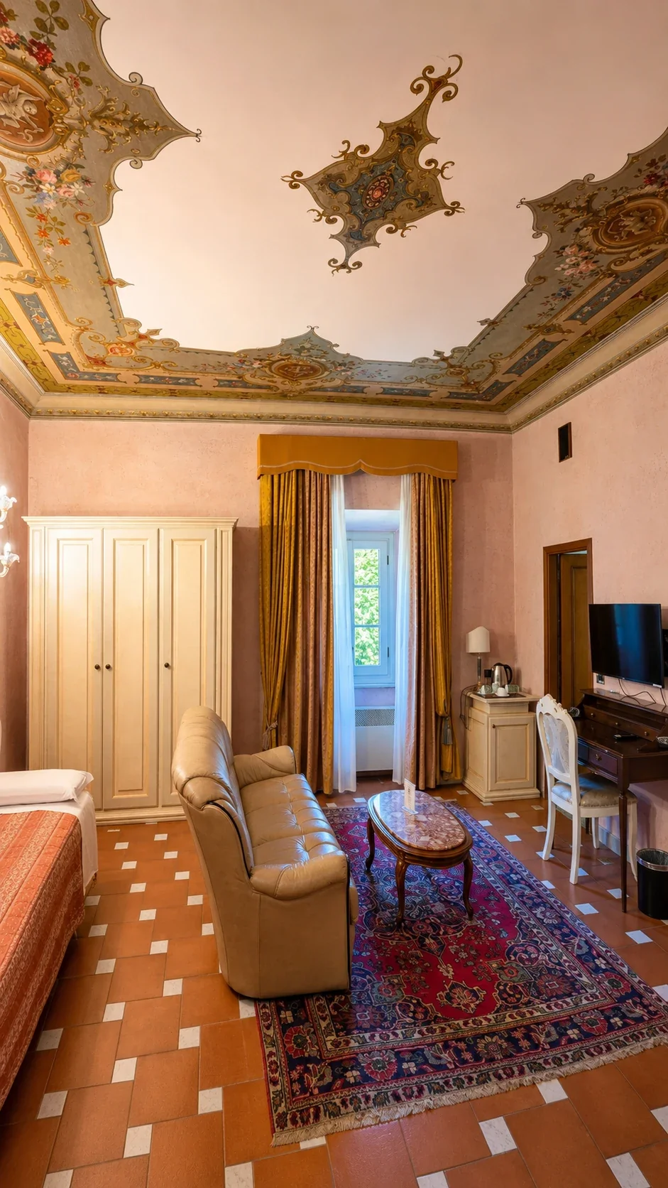 Il salotto con poltrone, tavolino e tappeto rosso sotto il soffitto decorato