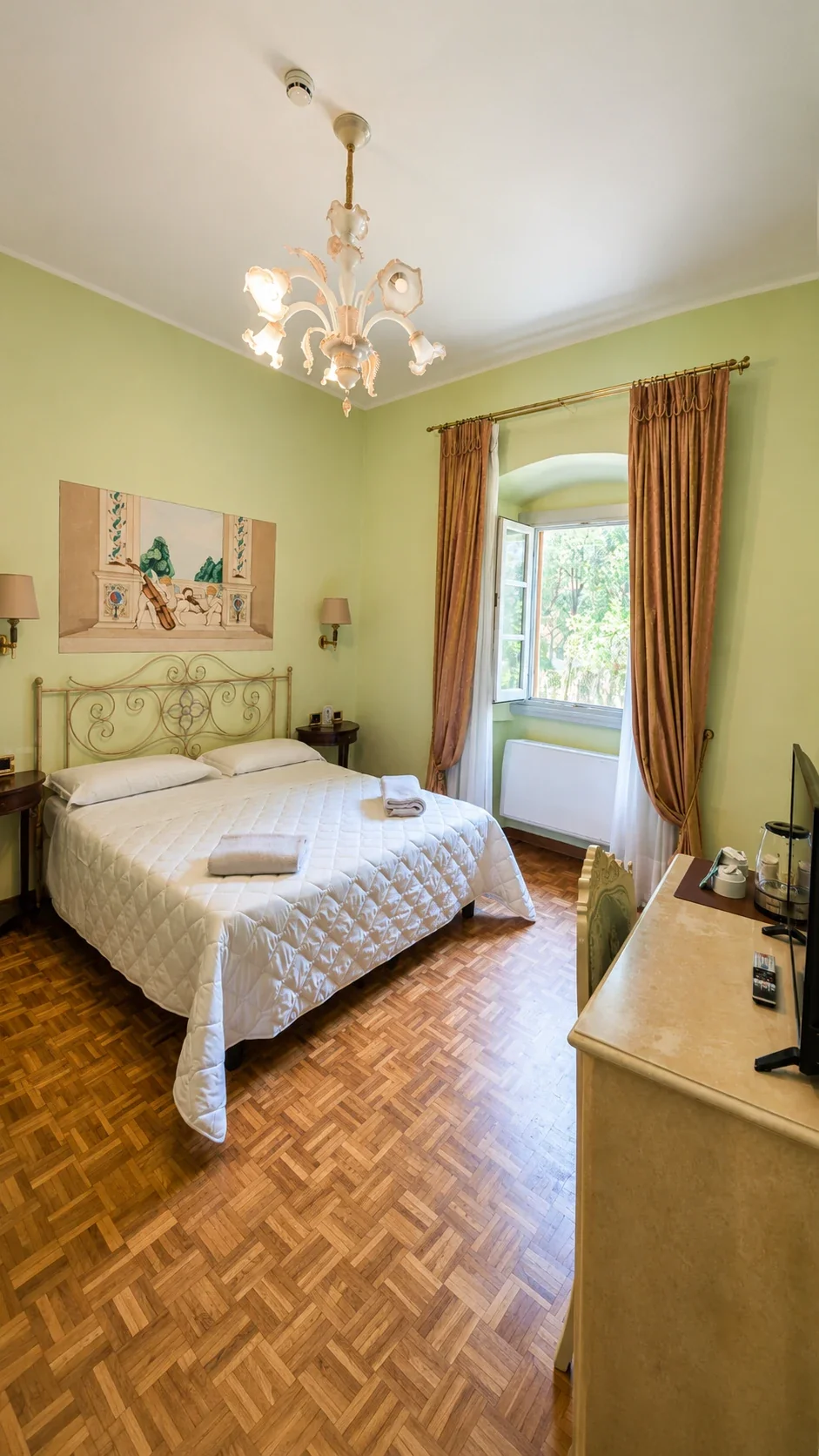 La Camera 209 dedicata a Terpsicore La Camera 209 con letto in ferro battuto, dipinto di Terpsicore e finestra aperta sul verde