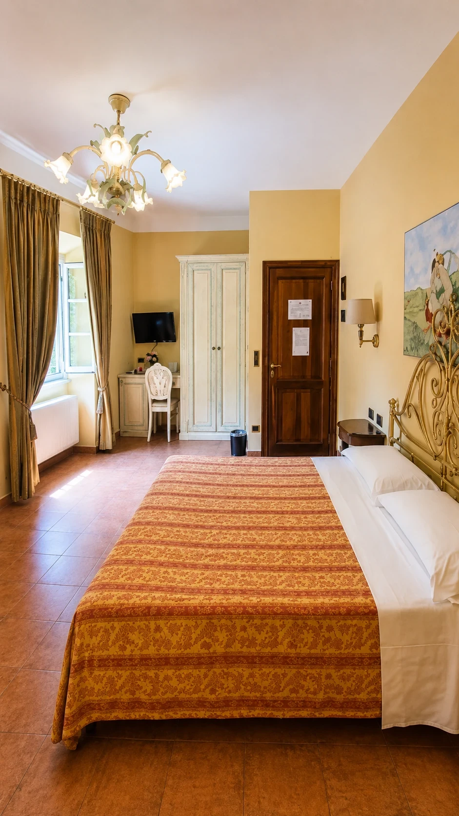 La Camera 215 con letto in ferro battuto dorato, dipinto di Amore e Psiche e arredi chiari